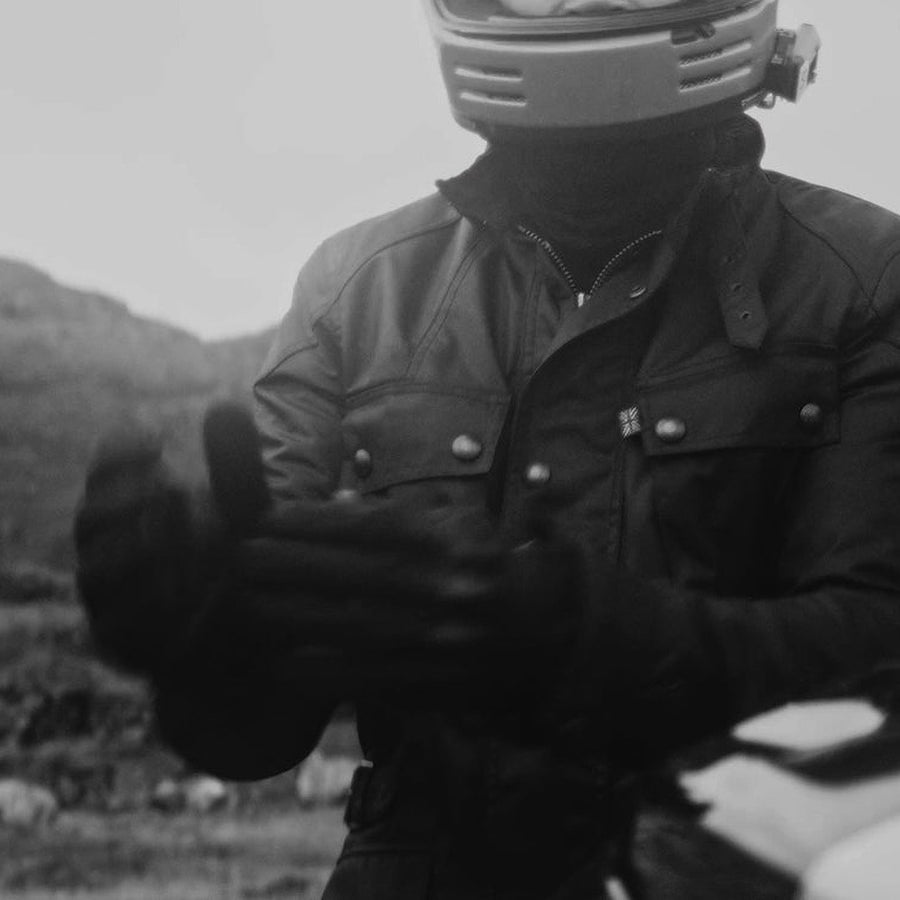 BELSTAFF のワックスジャケットを着て、グローブをはめるライダー